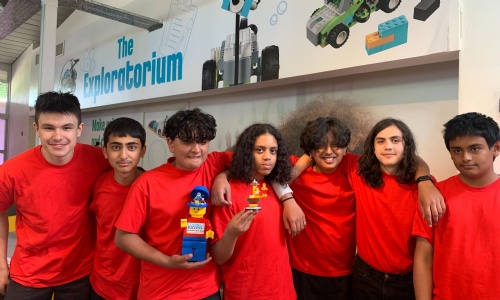 Robotics team holding lego trophy
